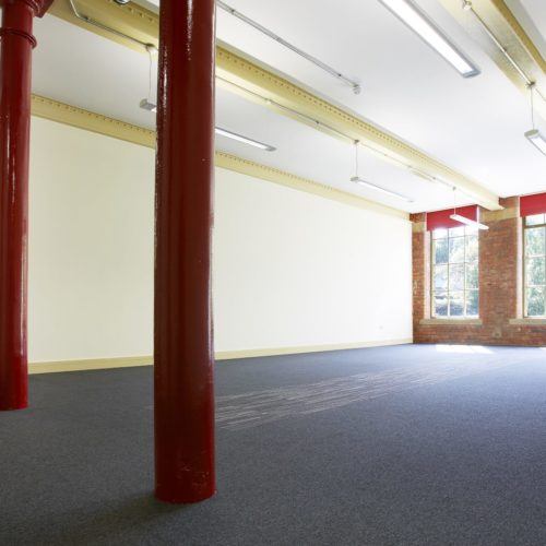 Empty business space with red pillars at Sunny Bank Mills., Leeds.