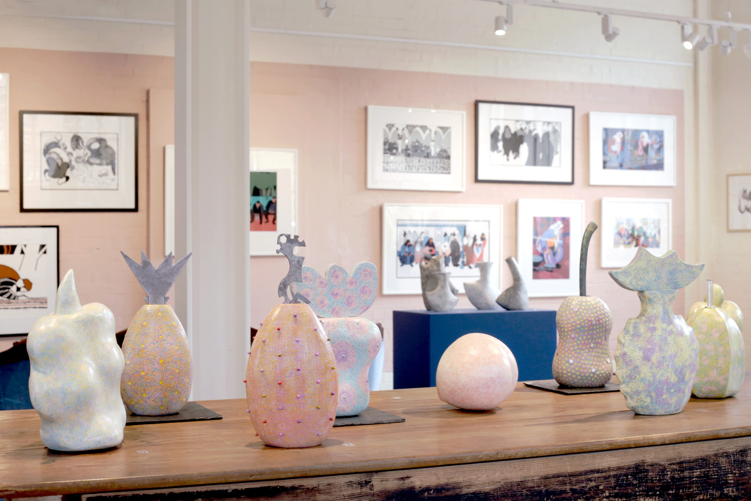 Fruit sculptures on a table with paintings on the walls.