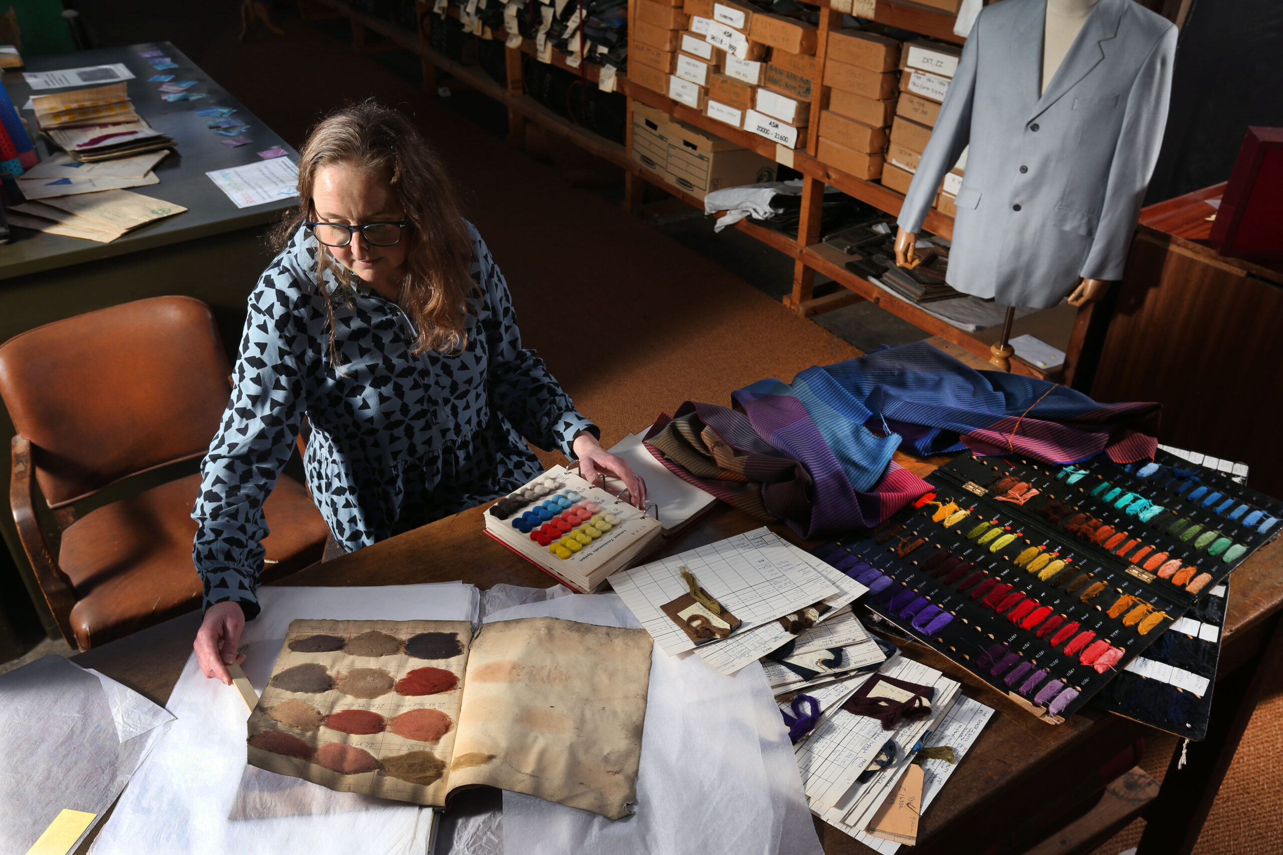 Rachel Moaby in the Museum & Archive at Sunny Bank Mills with an historic dye ledger
